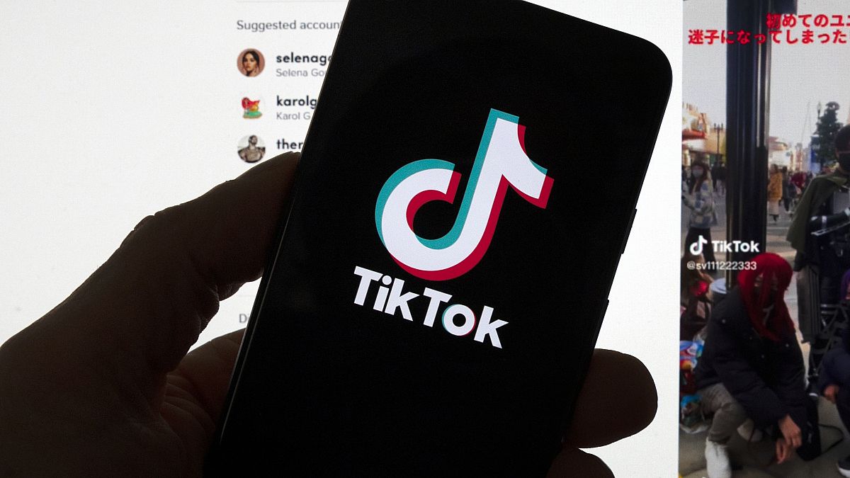 FILE - The TikTok logo is seen on a mobile phone in front of a computer screen which displays the TikTok home screen, Saturday, March 18, 2023, in Boston.