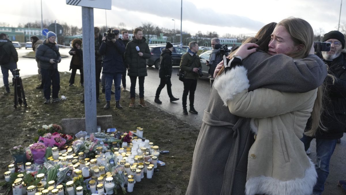 People gather at a makeshift memorial near the scene of a shooting on the outskirts of Orebro, Sweden, Wednesday, Feb. 5, 2025.