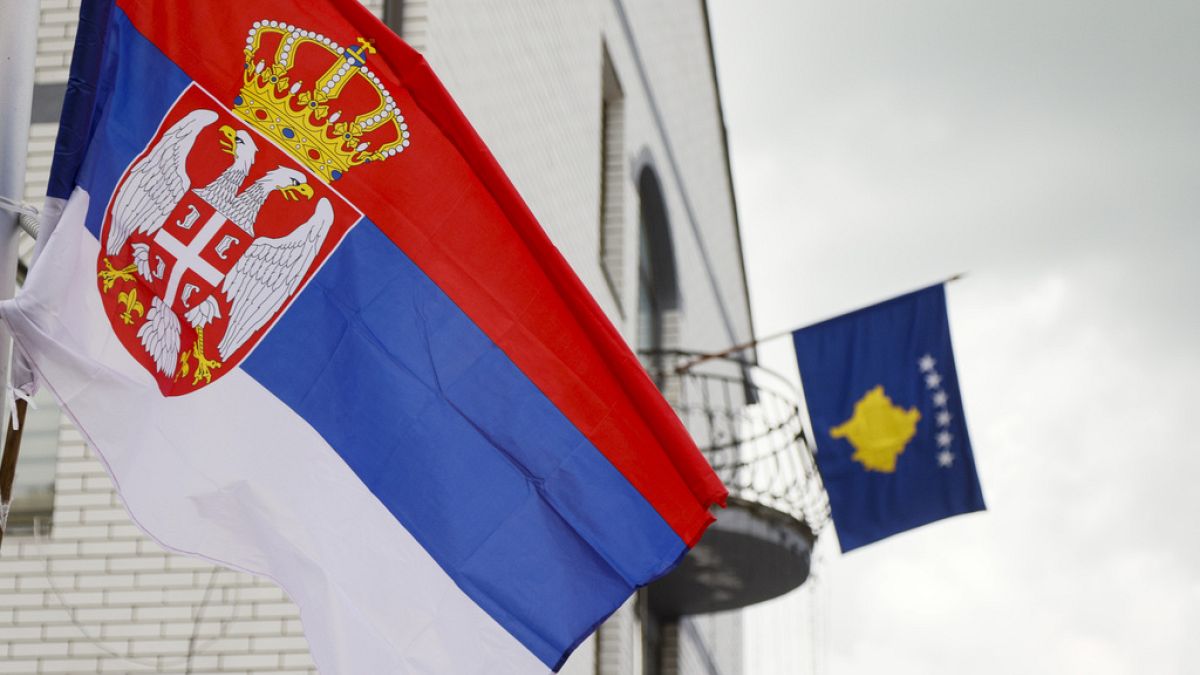 FILE - The Serbian flag, left, flies on a lamppost in front of a Kosovo flag on the city hall in the town of Zubin Potok, northern Kosovo, May 31, 2023.