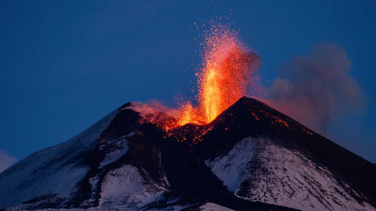 Lava erupts from snow-covered Mt Etna volcano, Sicily, Italy, early Friday, Dec. 1, 2023.