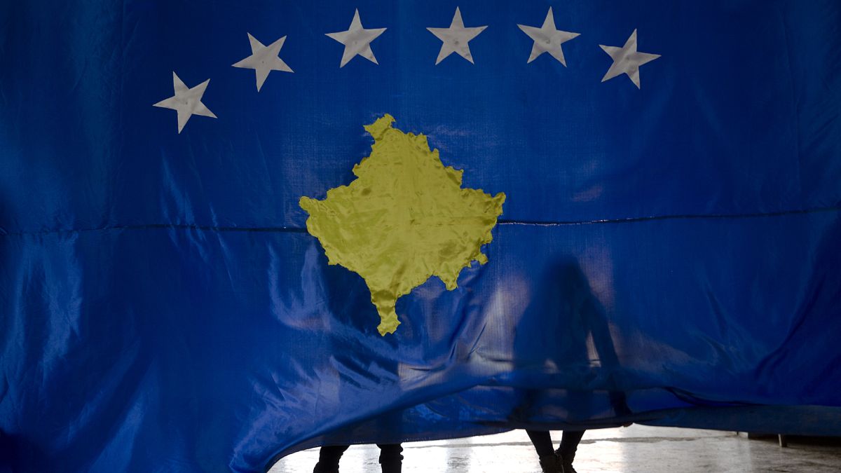 Students lift the flag of Kosovo during an independence celebration ceremony at a school in Sllovi, 16 February, 2018