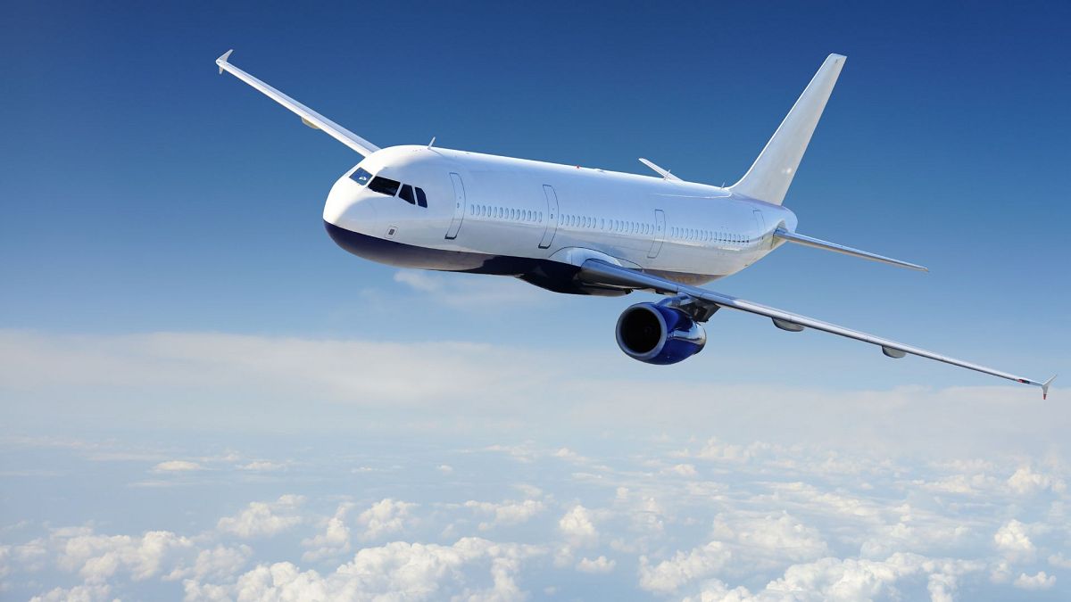 An aeroplane flying against a blue sky.