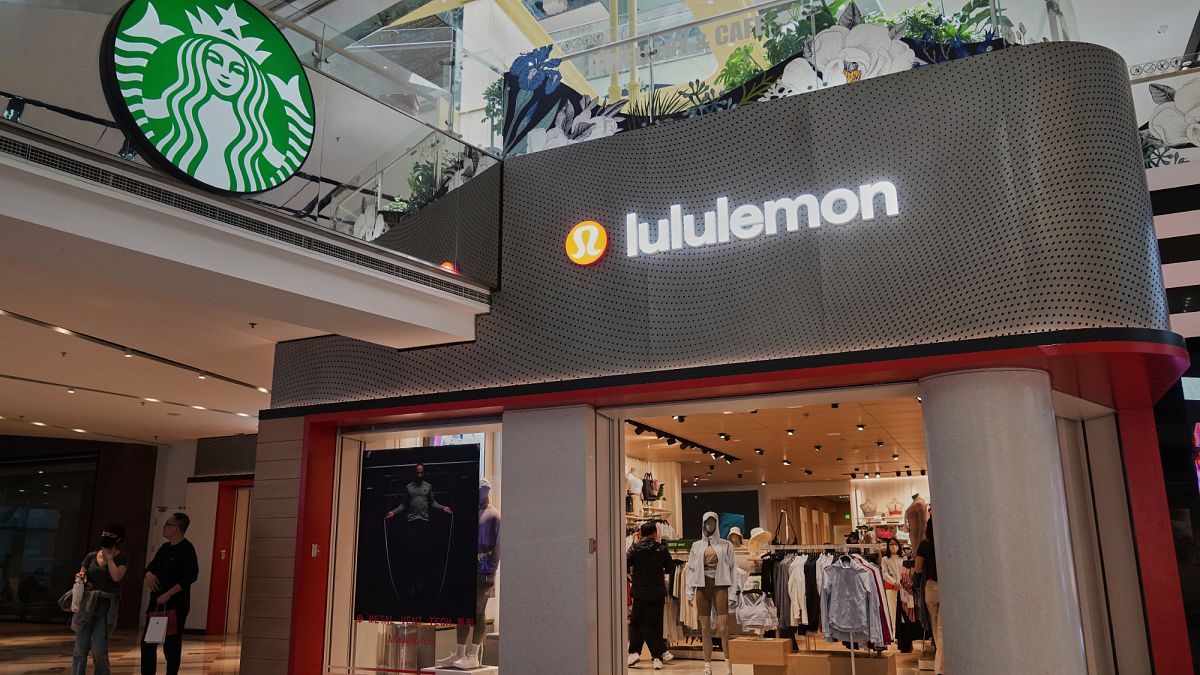Shoppers tour by a Starbuck cafe and a Lululemon store inside a shopping mall, in Beijing, China. 10 April 2025.