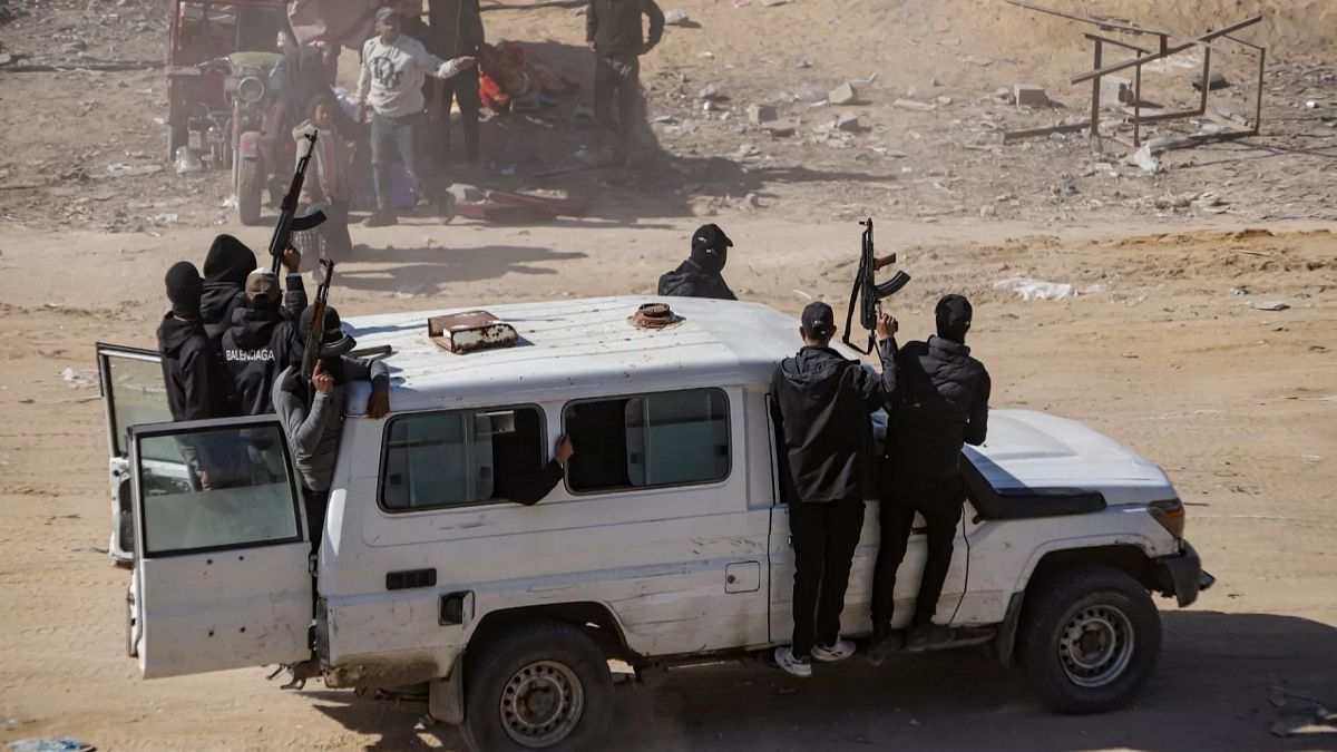 FILE - Hamas fighters secure aid trucks in Rafah, 21 January 2025, days after a ceasefire between Hamas and Israel went into effect.