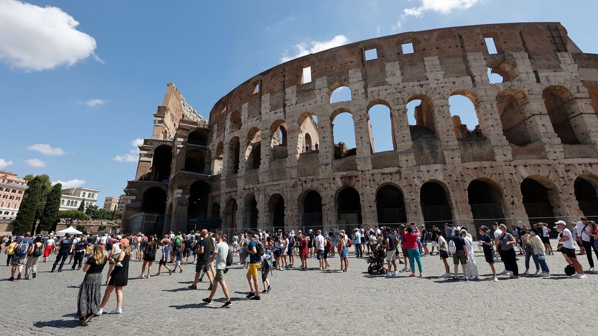 Tourists wait in a queue to enter the Colosseum in Rome, Italy.