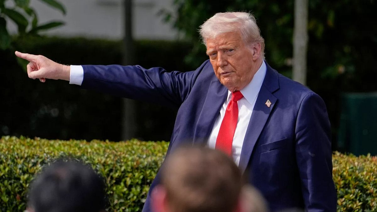 President Donald Trump gestures to the crowd as he departs after welcoming the 2025 College Football National Champions, the Ohio State University football team.