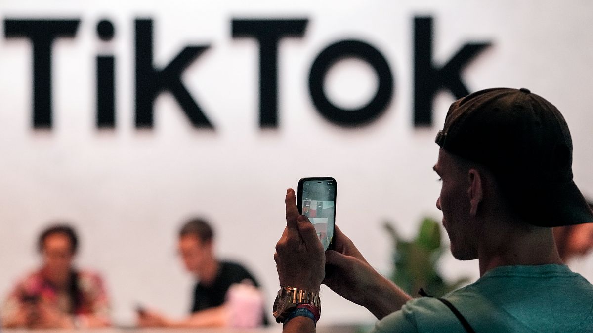 A visitor makes a photo at the TikTok exhibition stands at the Gamescom computer gaming fair in Cologne, Germany, Thursday, Aug. 25, 2022.