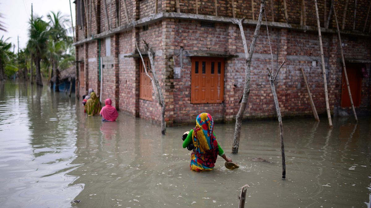 Villagers wade through waist-deep waters to reach their homes in Pratap Nagar, Bangladesh on Oct. 5, 2021. Saltwater reaches further inland as Bangladesh faces more cyclones.