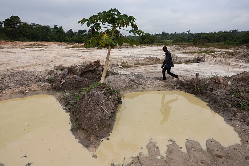 Ein Kakaobauer geht durch einen Teil seiner Farm, der dem Sandabbau in Kona, Ghana, überlassen wurde, 6. März 2026