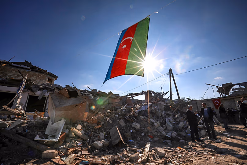 Die Nationalflagge Aserbaidschans weht über zerstörten Häusern in einem Wohngebiet, das über Nacht von armenischen Streitkräften in Ganja mit Raketenbeschuss getroffen wurde, 22. Oktober 2020