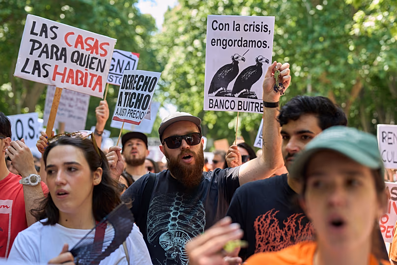 Mehrere Menschen halten während einer Protestkundgebung in Madrid, Spanien, am 24. Mai 2026 ein Transparent mit der Aufschrift: „Häuser für diejenigen, die darin leben“.