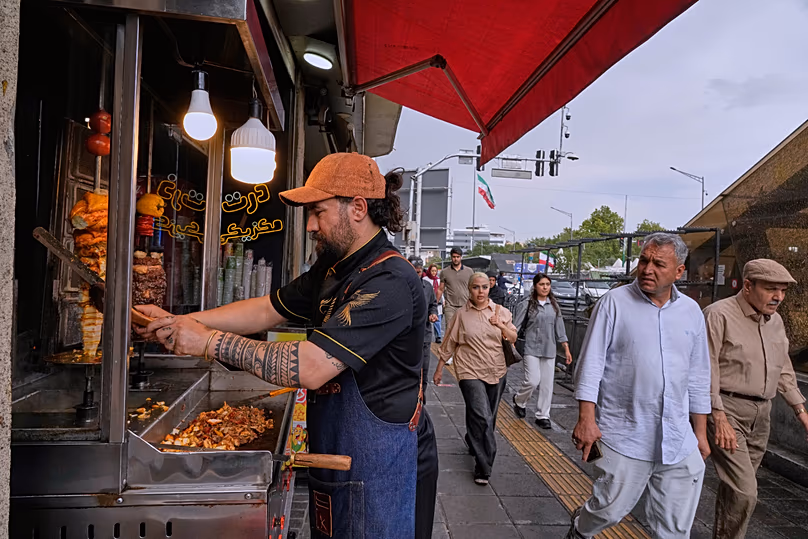 Ein Straßenverkäufer schneidet Döner an einem Imbissstand in der Innenstadt von Teheran, Iran