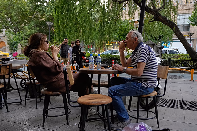 Menschen trinken Kaffee im Essbereich im Freien eines Cafés in der Nähe des alten Hauptbasars von Teheran, Iran