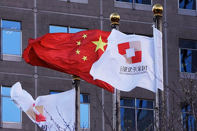 DATEI. Flaggen der China Development Bank wehen neben einer chinesischen Flagge vor einer Zweigniederlassung der Bank in Peking, Januar 2021
