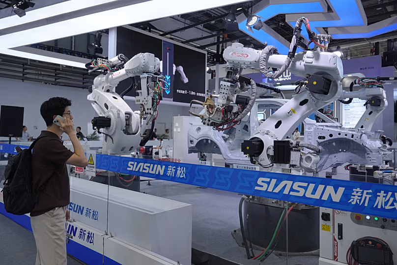 DATEI. Ein Besucher betrachtet Roboterarme für die industrielle Produktion auf der World Robot Conference in Peking, 19. August 2026