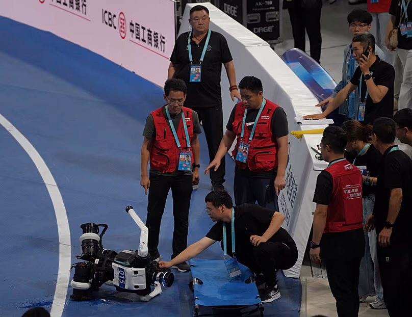 DATEI. Ein Techniker überprüft einen Roboter nach einem Sturz am Ende des 1.500-Meter-Laufs während der World Humanoid Robot Games in Peking, China, 23. August 2026