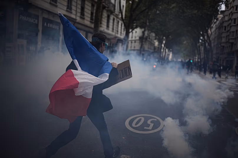 Ein Demonstrant hält eine französische Flagge während einer Demonstration gegen steigende Lebenshaltungskosten in Lyon, Frankreich, Samstag, 24. Oktober 2026.